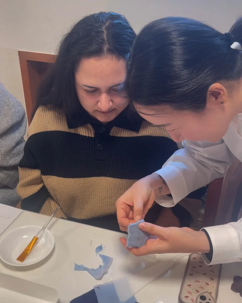 Instructor demonstrating details of a blue hanji craft